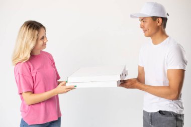 The delivery man gives the pizza to the client.