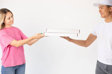 The delivery man gives the pizza to the client.