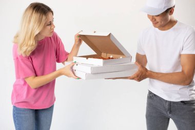 The delivery man gives the pizza to the client.