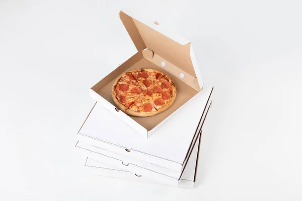 Pizza in an open box on a white background.