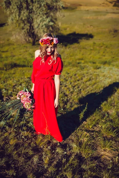 Chica en el vestido rojo está caminando en el campo —  Fotos de Stock