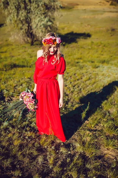 Chica en el vestido rojo está caminando en el campo —  Fotos de Stock