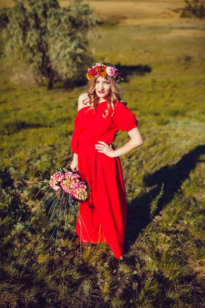 Chica en el vestido rojo está caminando en el campo —  Fotos de Stock