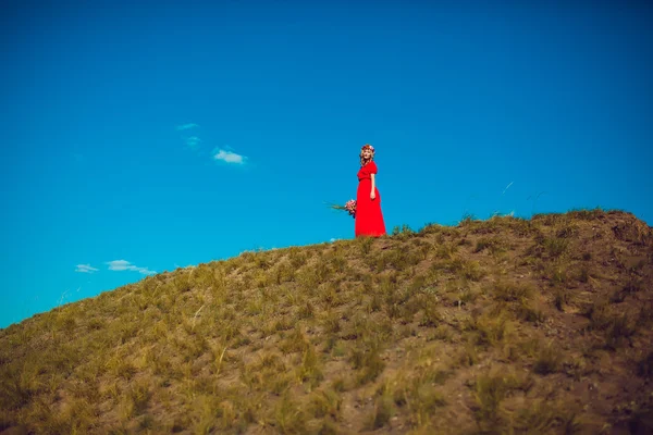 Chica en el vestido rojo está caminando en el campo —  Fotos de Stock