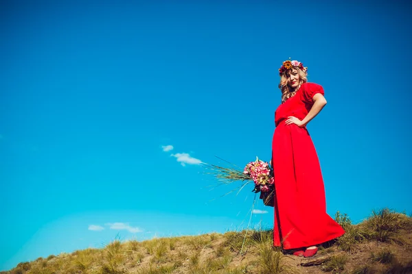 Chica en el vestido rojo está caminando en el campo —  Fotos de Stock