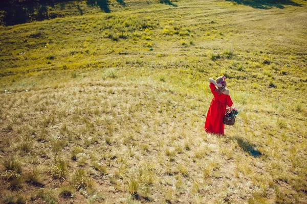 Chica en el vestido rojo está caminando en el campo —  Fotos de Stock