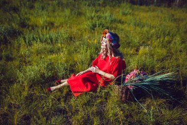 Kırmızı elbiseli kız sahada yürüyor