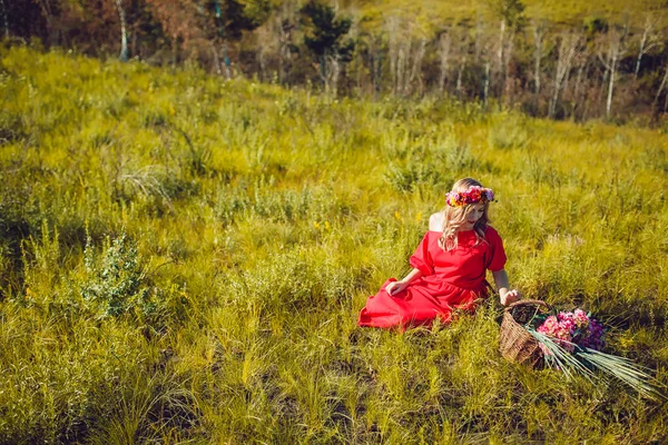 Kırmızı elbiseli kız sahada yürüyor — Stok fotoğraf