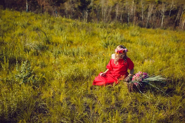 Fille dans la robe rouge marche sur le terrain — Photo