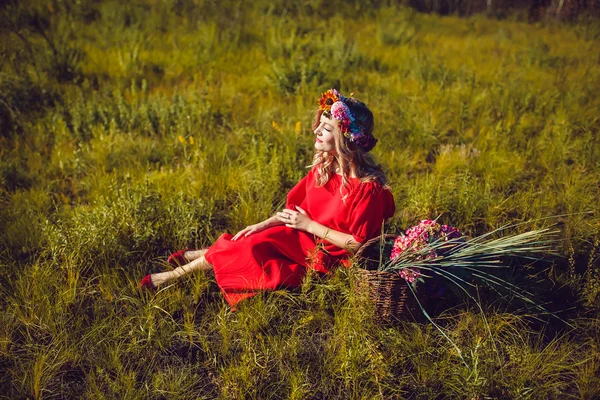 Menina no vestido vermelho está andando No campo — Fotografia de Stock