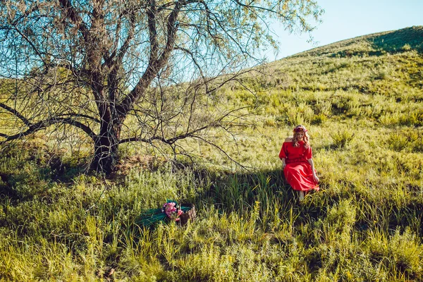 Fille dans la robe rouge marche sur le terrain — Photo