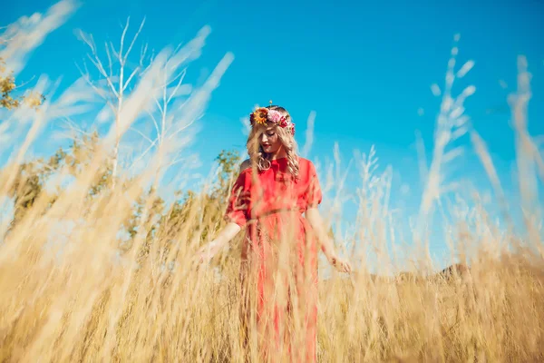 Chica en el vestido rojo está caminando en el campo —  Fotos de Stock