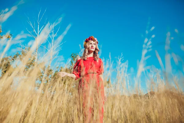 Chica en el vestido rojo está caminando en el campo —  Fotos de Stock