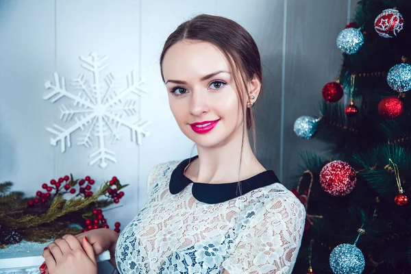 Schönes Mädchen auf dem Hintergrund der Neujahrsdekoration — Stockfoto