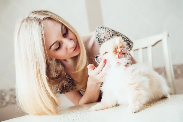 Hermosa mujer rubia con su perro en un hermoso interior — Foto de Stock