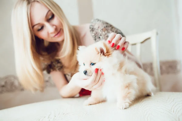 Vacker blond kvinna med sin hund i en vacker interiör — Stockfoto