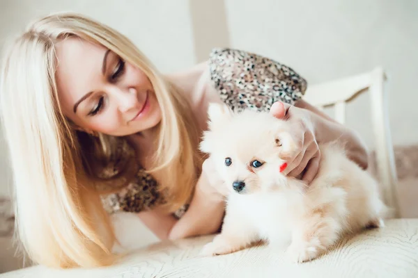 Женщина-блондинка с собачкой в руках — стоковое фото