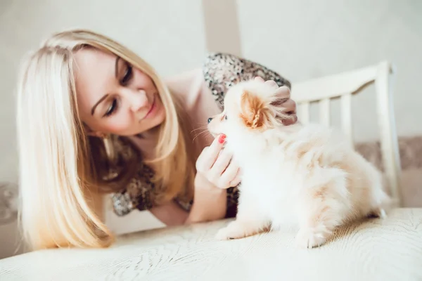 Hermosa mujer rubia con su perro en un hermoso interior — Foto de Stock