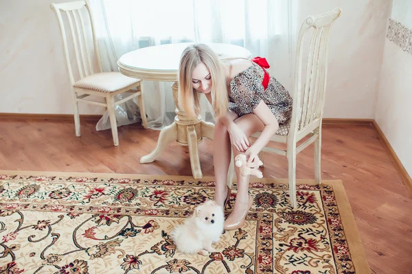 Mulher loira bonita com seu cão em um belo interior — Fotografia de Stock