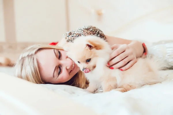 Hermosa mujer rubia con su perro en un hermoso interior — Foto de Stock