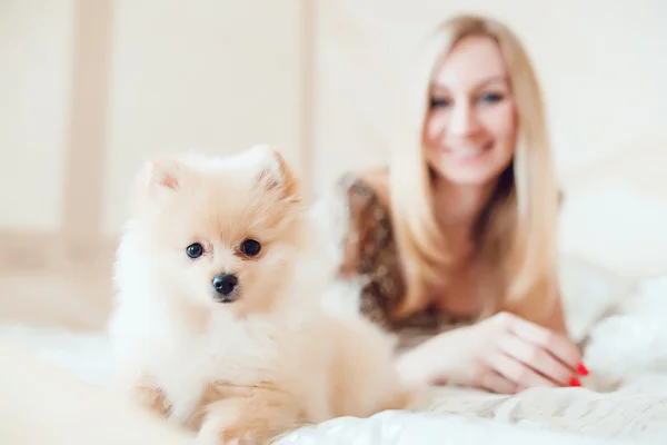 Piękna blond kobieta z psem w pięknym wnętrzu — Zdjęcie stockowe