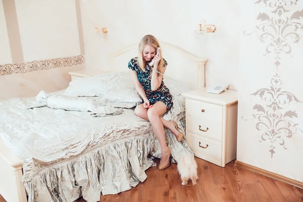Hermosa mujer rubia con su perro en un hermoso interior — Foto de Stock