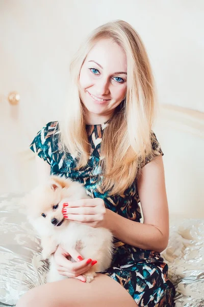 Schöne blonde Frau mit ihrem Hund in einem schönen Interieur — Stockfoto