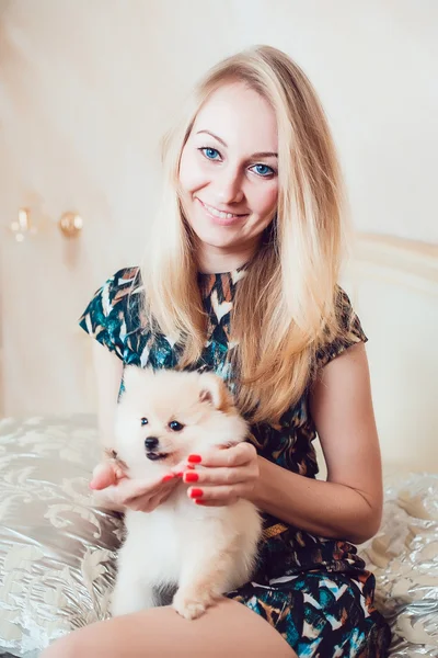 Mulher loira bonita com seu cão em um belo interior — Fotografia de Stock