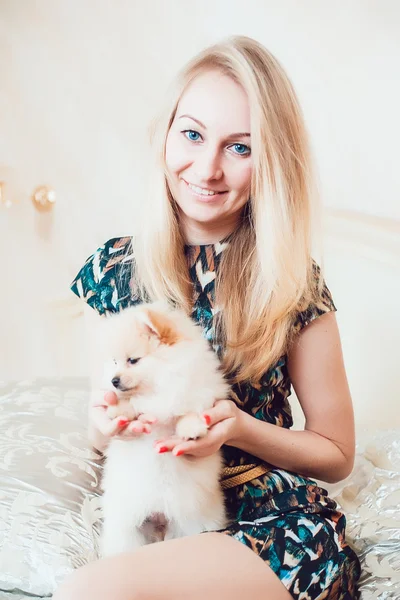 Schöne blonde Frau mit ihrem Hund in einem schönen Interieur — Stockfoto