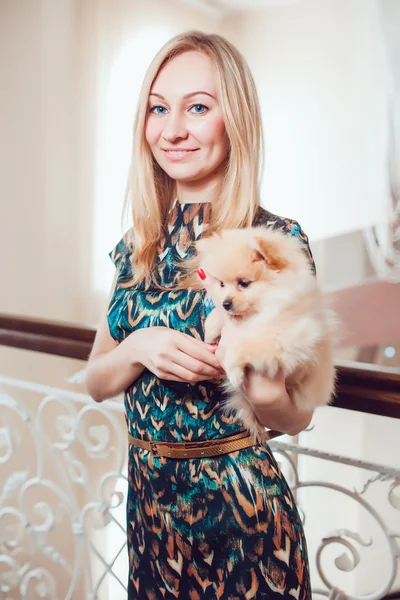 Schöne blonde Frau mit ihrem Hund in einem schönen Interieur — Stockfoto