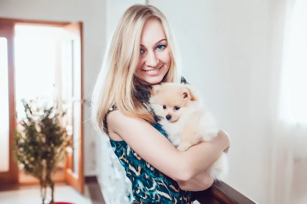 Mulher loira bonita com seu cão em um belo interior — Fotografia de Stock