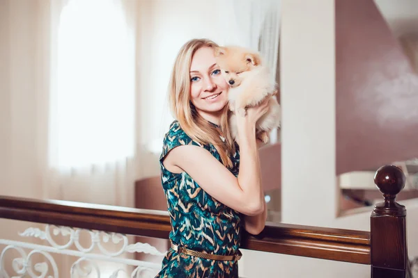 Schöne blonde Frau mit ihrem Hund in einem schönen Interieur — Stockfoto