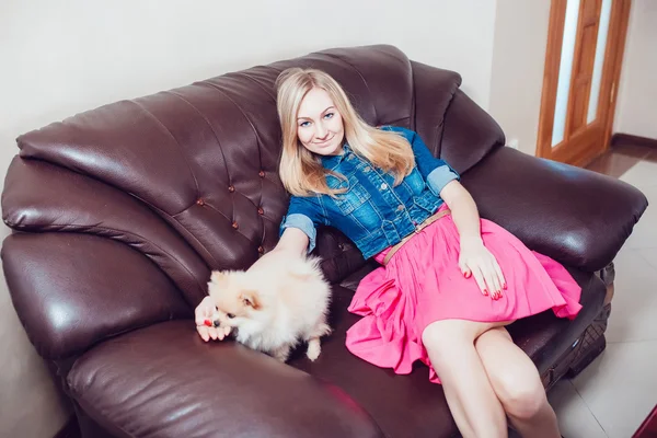 Schöne blonde Frau mit ihrem Hund in einem schönen Interieur — Stockfoto