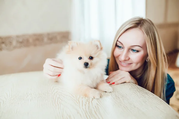 Vacker blond kvinna med sin hund i en vacker interiör — Stockfoto