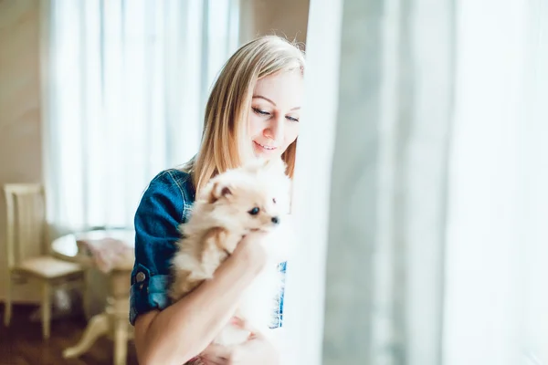 Mulher loira bonita com seu cão em um belo interior — Fotografia de Stock