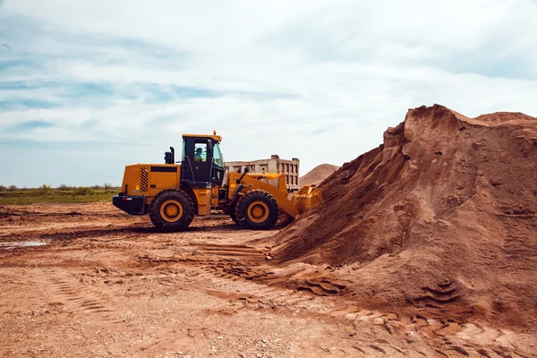 Excavadora carga grava en un camión en una cantera de piedra aplastada — Foto de Stock