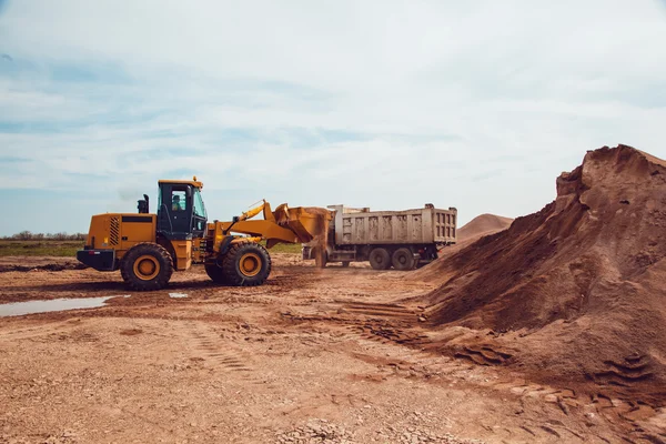 Excavator Loads Gravel into a Truck on a Crushed Stone Quarry — Stock Photo, Image