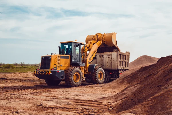 Ezilmiş taş ocağı bir kamyonetin içine Ekskavatör yükler stabilize