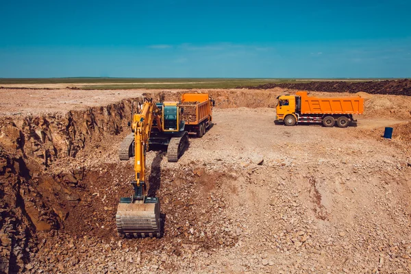 Excavadora carga grava en un camión en una cantera de piedra aplastada — Foto de Stock