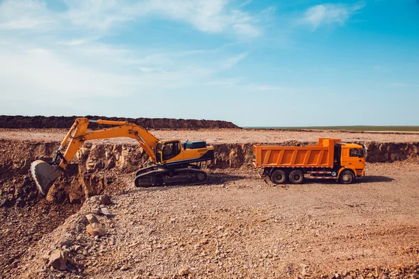 Excavator Loads Gravel into a Truck on a Crushed Stone Quarry — Stock Photo, Image