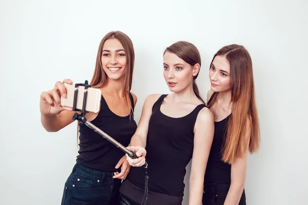 Beautiful young girls taking a photo with selfie stick — Stock Photo, Image
