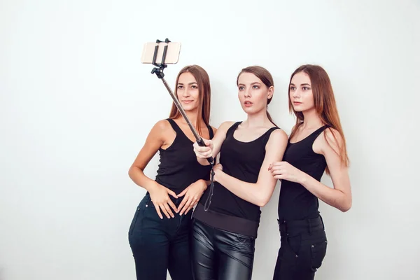 Beautiful young girls taking a photo with selfie stick — Stock Photo, Image