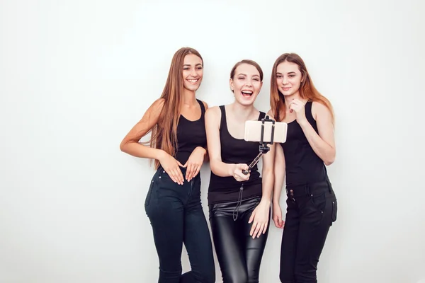 Schöne junge Mädchen machen ein Foto mit Selfie-Stick — Stockfoto