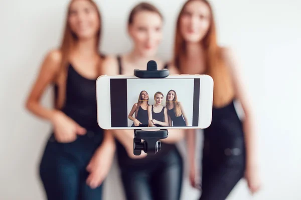 Beautiful young girls taking a photo with selfie stick — Stock Photo, Image