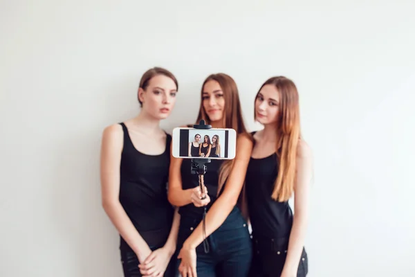 Beautiful young girls taking a photo with selfie stick — Stock Photo, Image