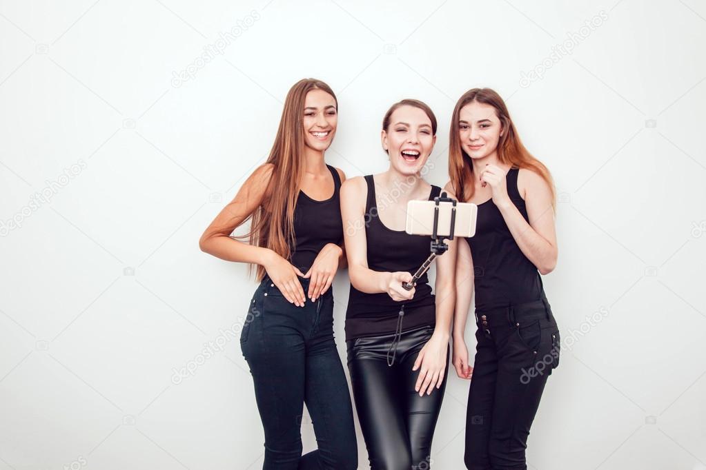 Beautiful young girls taking a photo with selfie stick