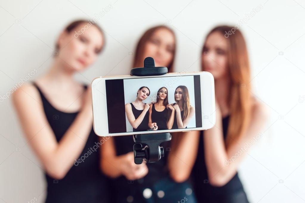 Beautiful young girls taking a photo with selfie stick