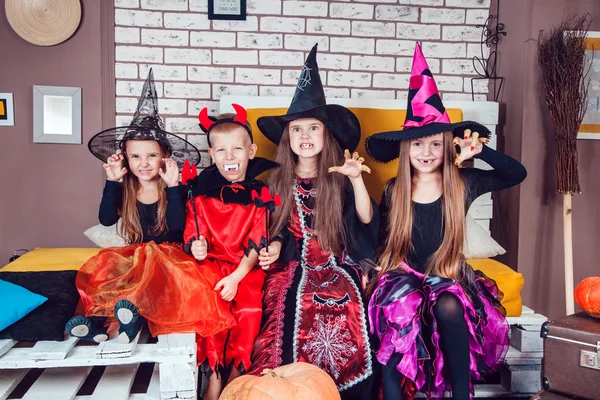 Boys and girls, dressed up in Halloween costumes, show emotions of witches and vampires. Halloween party with group children. — ストック写真