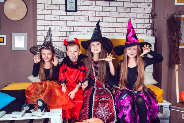 Jungen und Mädchen in Halloween-Kostümen zeigen Emotionen von Hexen und Vampiren. Halloween-Party mit Kindern in der Gruppe. — Stockfoto