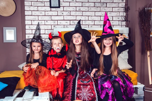 Boys and girls, dressed up in Halloween costumes, show emotions of witches and vampires. Halloween party with group children. — ストック写真